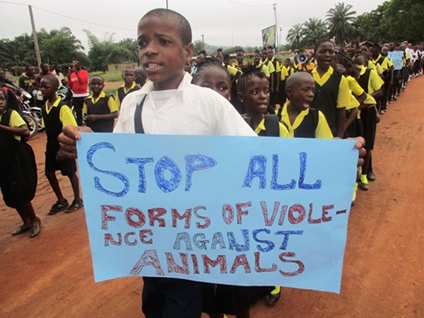 Group of children and a boy holding poster with against violence slogan