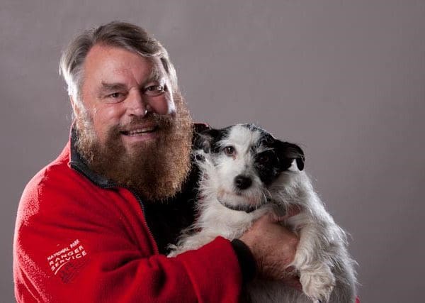 Brian Blessed Headshot holding a white dog